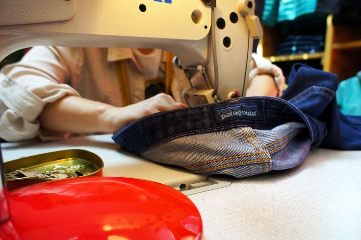 una sarta passa a macchina un pantalone jeans Patagonia da riparare