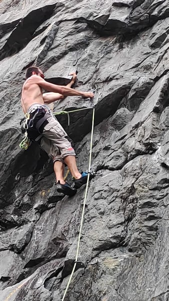 alpinista arrampica su parete di roccia