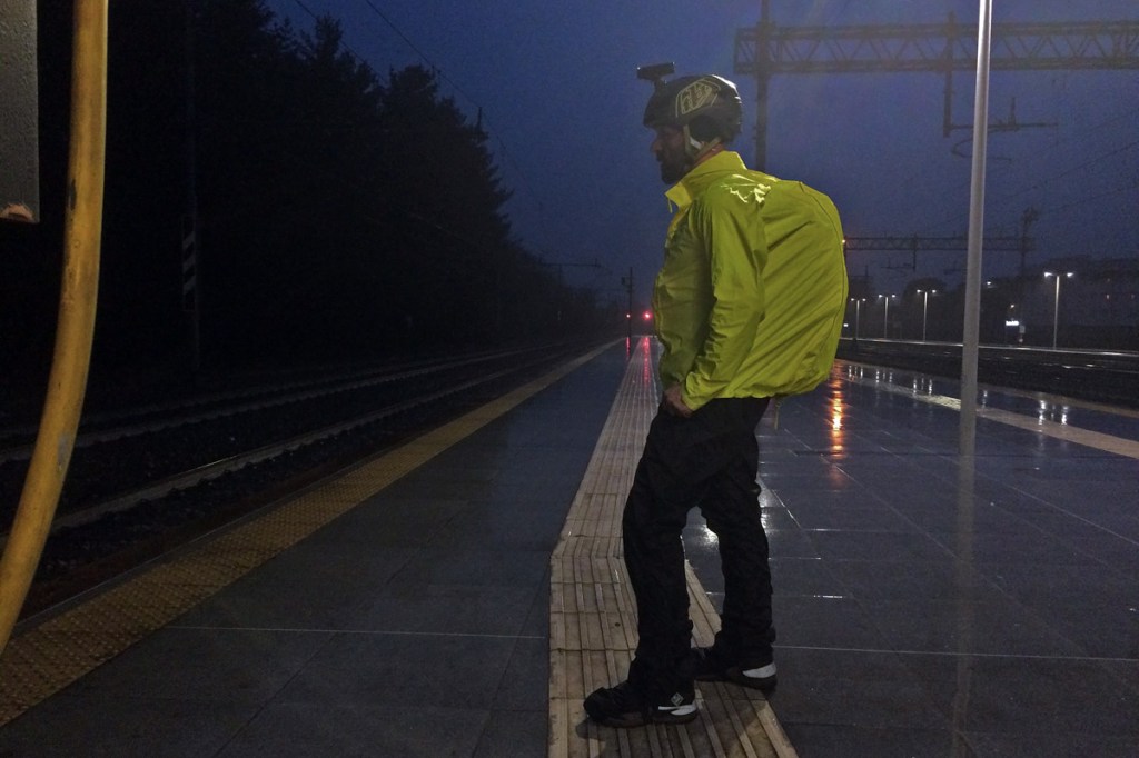 in foto un ciclista sotto il temporale indossa una giacca e un pantalone antipioggia