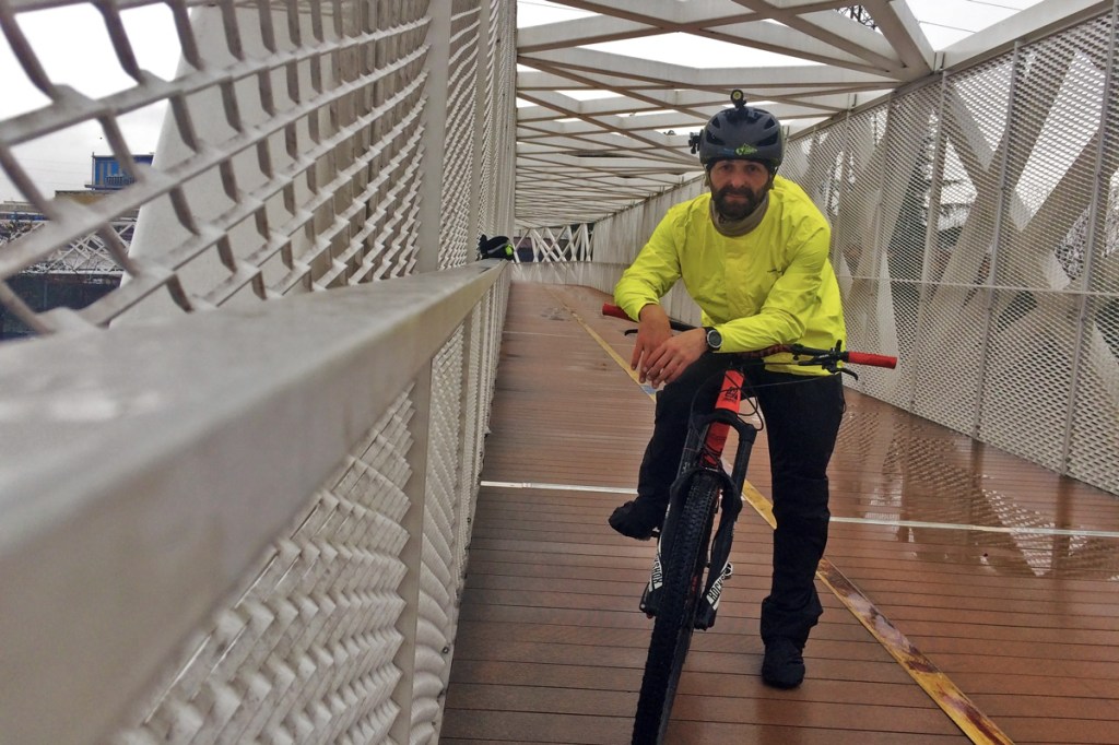 in foto ciclista sotto il temporale indossa giacca e pantalone antipioggia