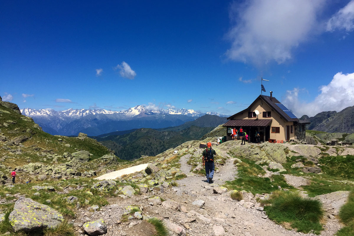 in foto il rifugio benigni adagiato su un altopiano alla base della cima piazzotti e poco distante dall'omonimo lago