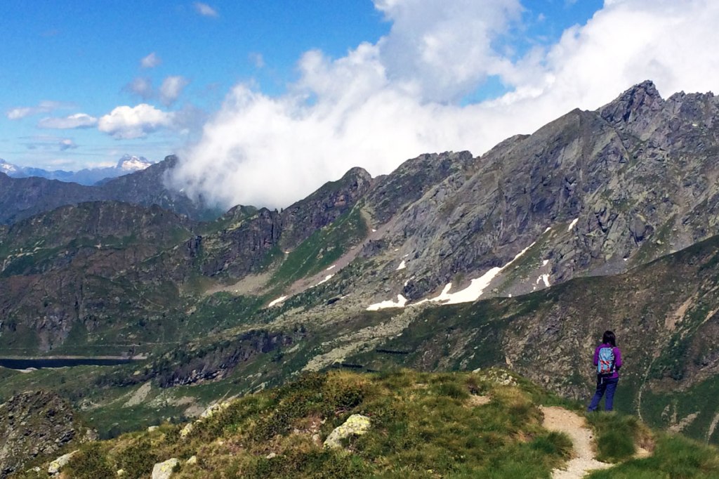 in foto una ragazza si gode la vista sulla vallata dall'altopiano su cui è collocato il rifugio benigni ai piedi della cima piazzotti