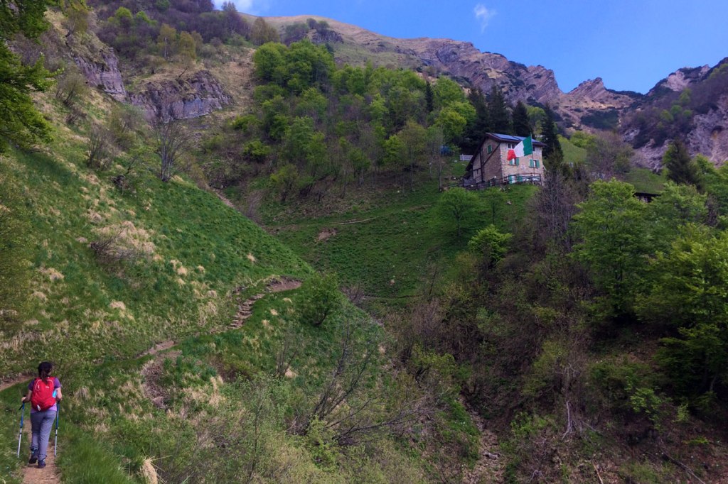 un'escursionista si accinge a percorrere gli ultimi metri di sentiero che conducono al rifugio elisa da rongio