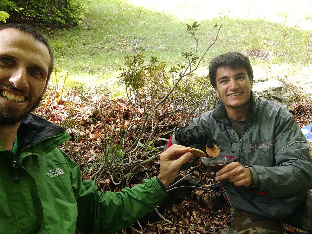 due escursionisti all'aria apera approfittano di una bevanda calda e biscotti per fare una pausa