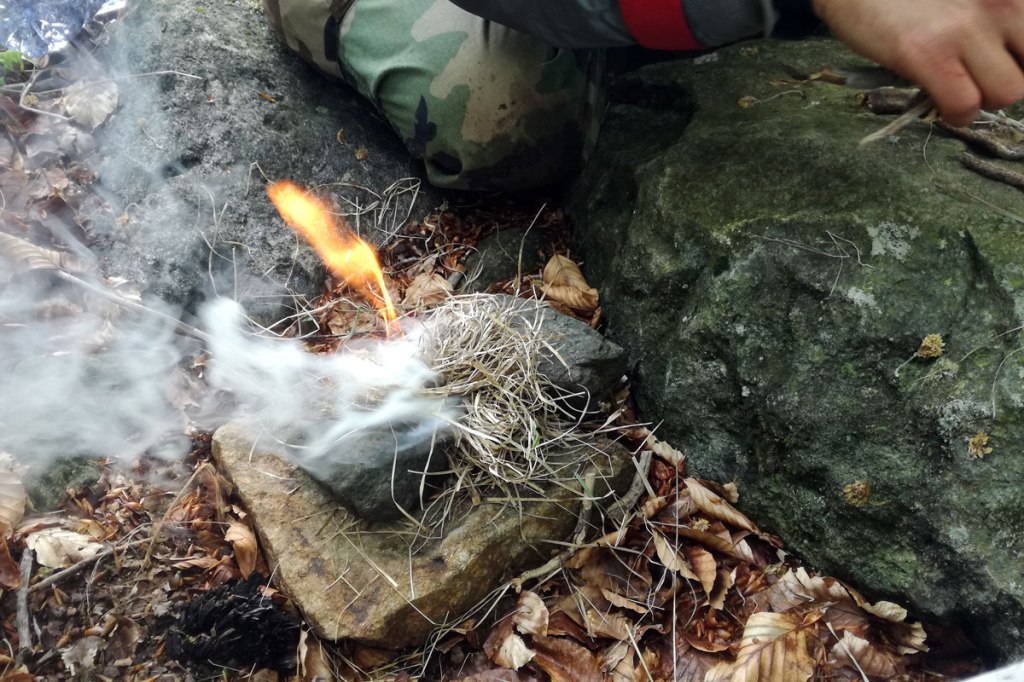 un fuoco accesso all'aria aperta grazie a paglia secca e un acciarino