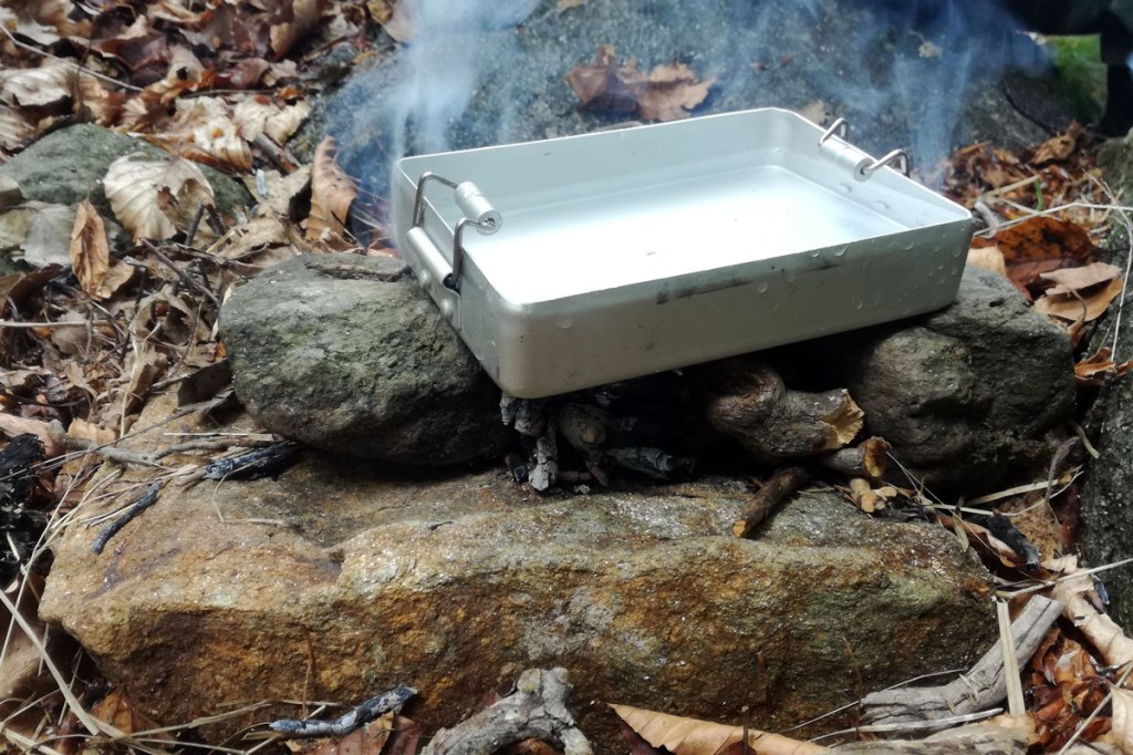 un gavettino in alluminio sul fuoco per scaldare l'acqua e preparare un caffè