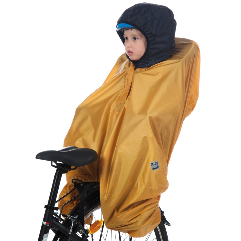 un bambino seduto sul seggiolino della bicicletta è riparato dalla pioggia grazie al copri-seggiolino impermeabile opossum tucano urbano
