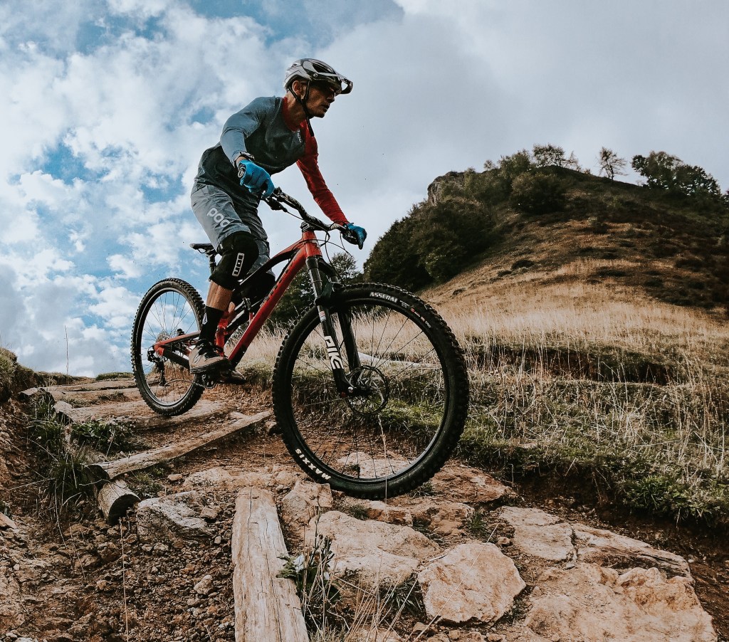 un atleta in mountain bike affronta un passaggio con sassi