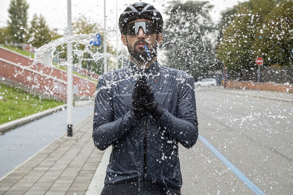 un ciclista investito da una colonna d'acqua