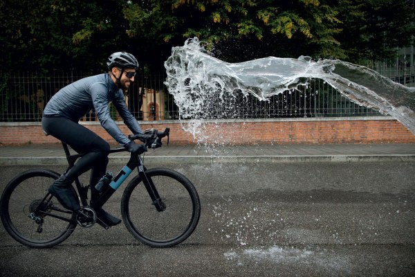 un ciclista investito da una colonna d'acqua