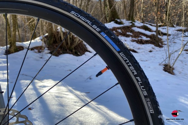 la spalla di uno pneumatico invernale chiodato per bicicletta con scritte e fascia catarifrangente