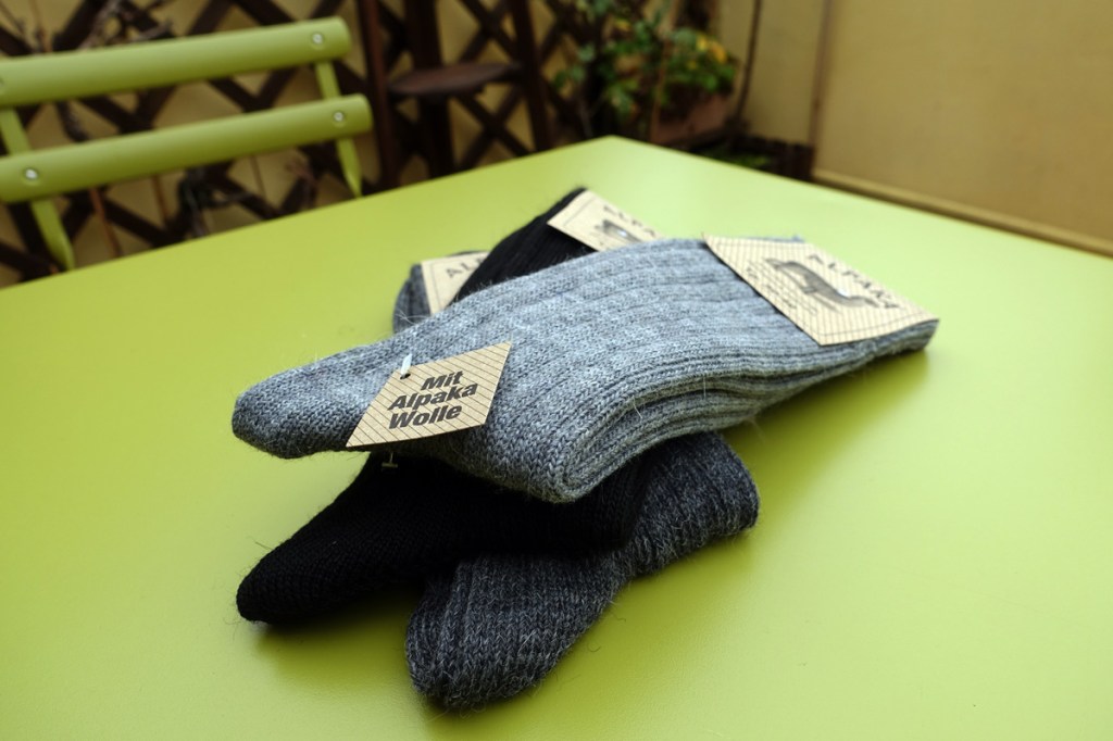calze in lana di vari colori impilate su un tavolo verde