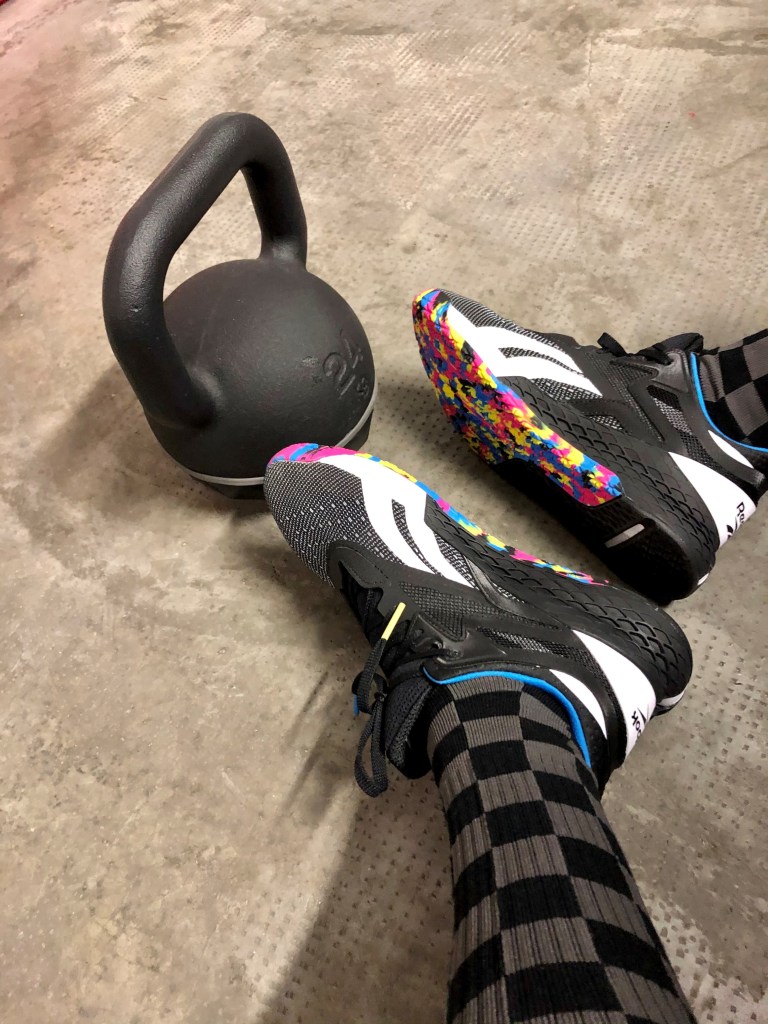 un peso kettlebell da 24 kg ed un paio di scarpe da allenamento crossfit indoor