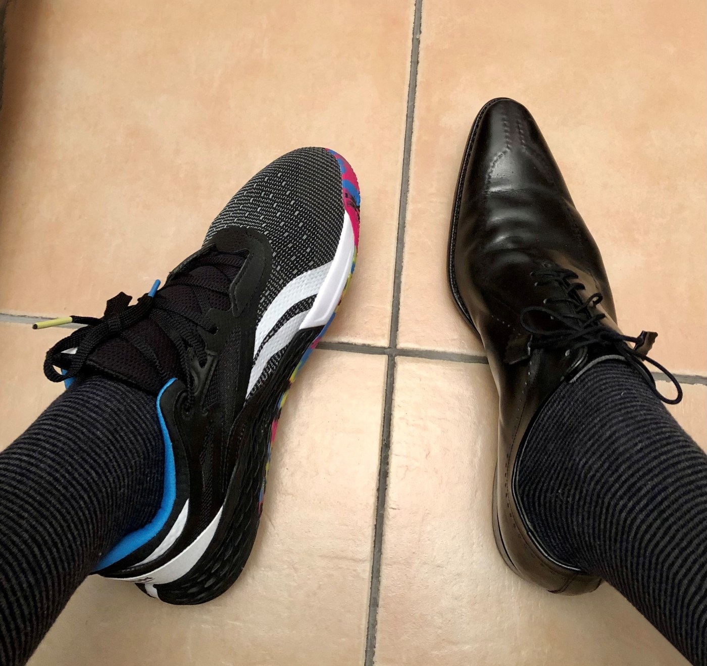 un mocassino classico nero a punta ed una scarpa sportiva per la pratica del crossfit