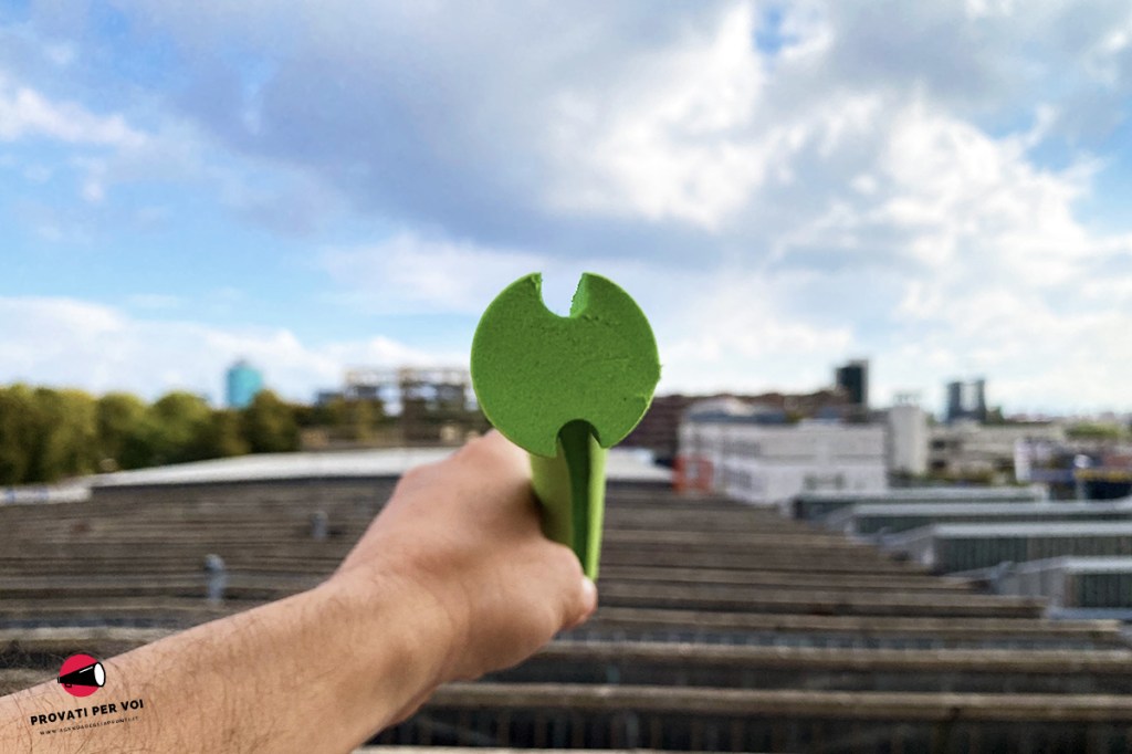 un cilindro in plastica EVA di colore verde visto dalla sezione trasversale e sullo sfondo la skyline milanese