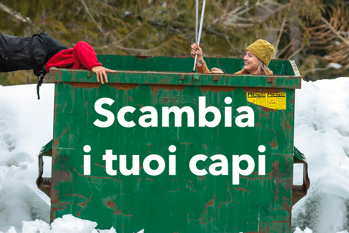 due ragazze dentro un bidone dell'immondizia verde fanno finta di raccogliere indumenti