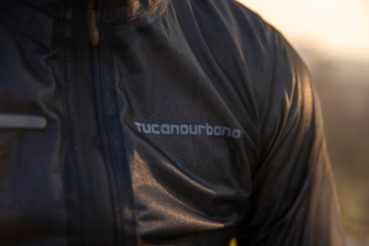 primo piano sulla scritta catarifrangente stampata sulla membrana idrorepellente di una giacca antipioggia da ciclismo