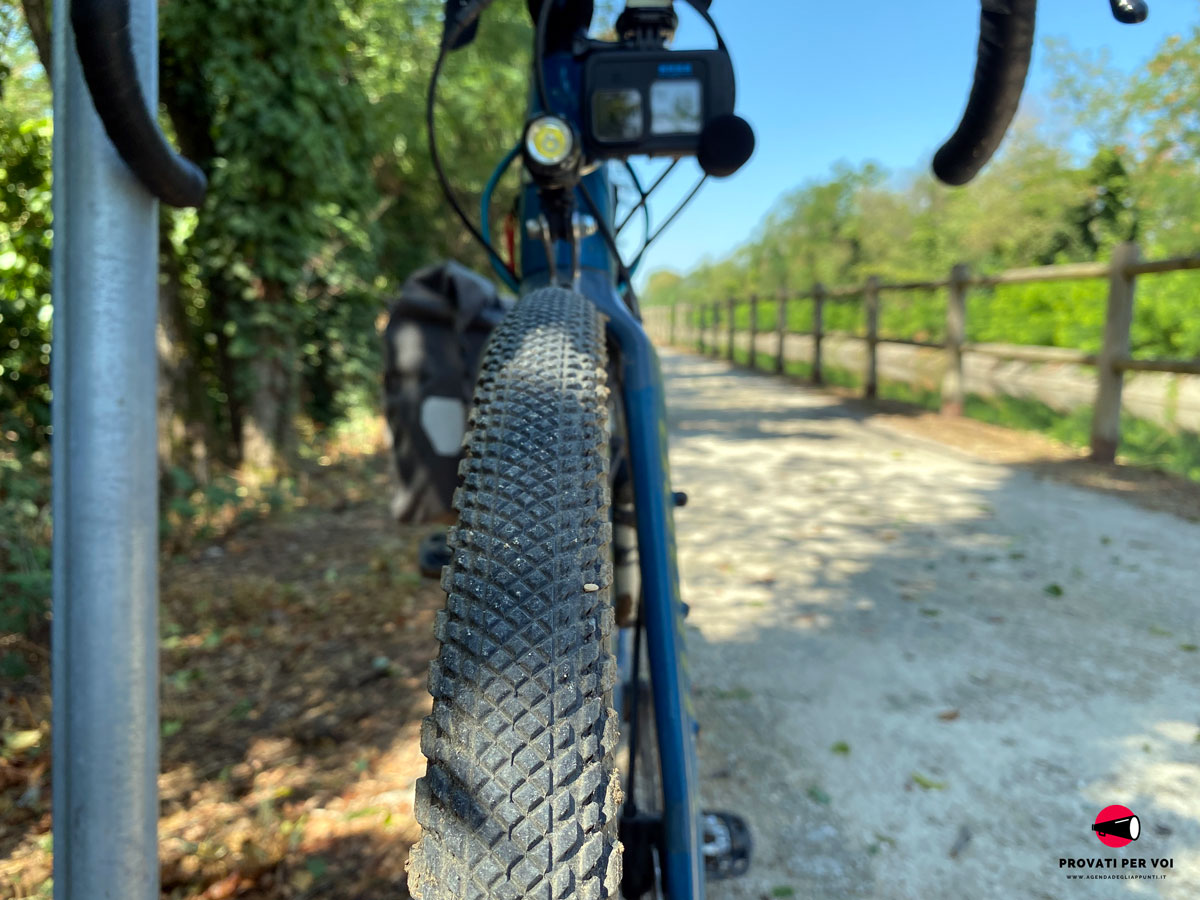 il battistrada di uno pneumatico per gravel bike e una strada bianca sterrata vicino ad un canale