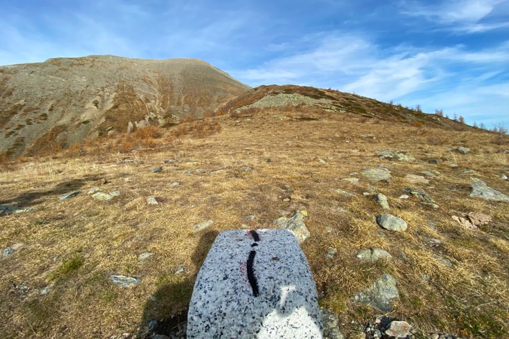 il cippo di confine tra Italia e Svizzera al Passo di Monscera in Alta Valle Bognanco e sullo sfondo la vetta di una montagna