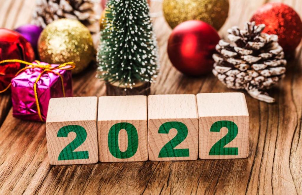 composizione natalizia di palline, pacchetti infiocchettati, pigne, un abete, blocchi di legno con numeri