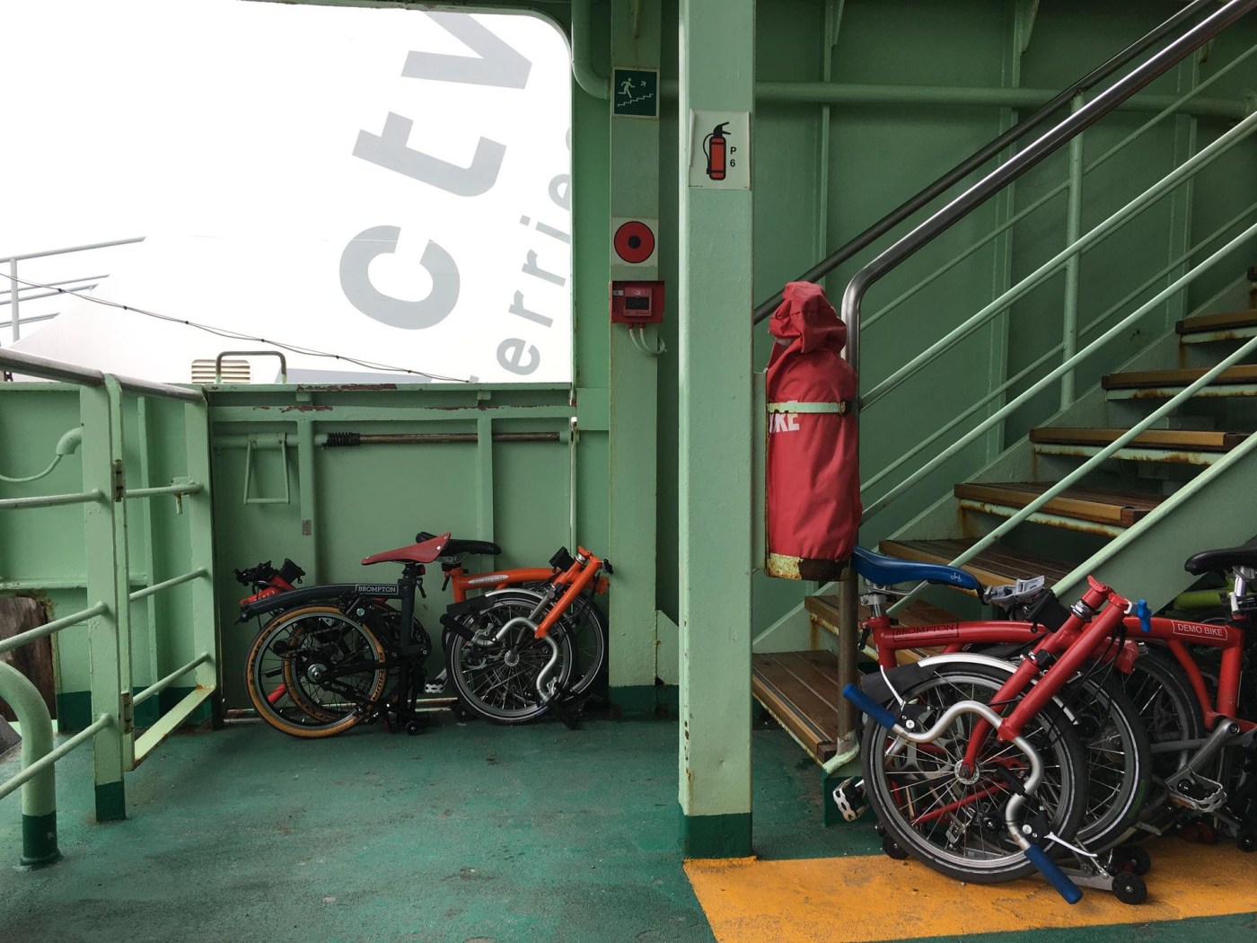 biciclette pieghevoli occupano pochissimo spazio alla base di una scala di ferro sul ponte di un traghetto