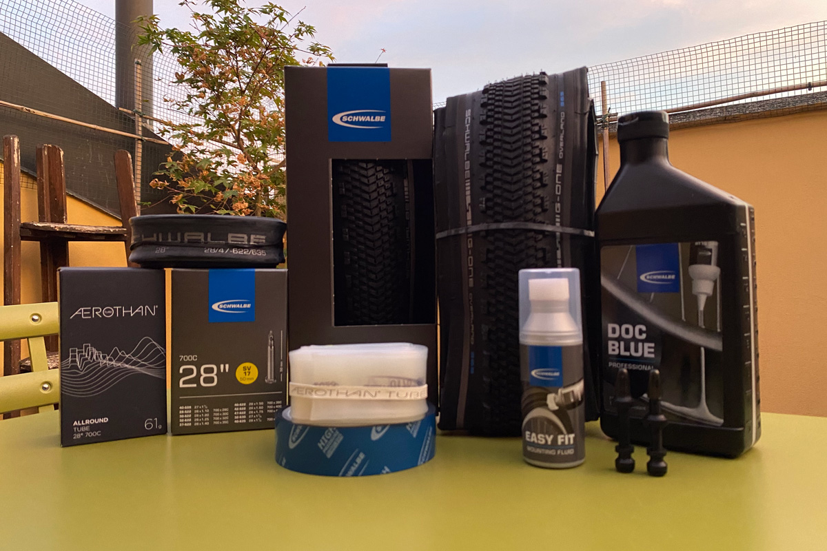 pneumatici gravel bike e accessori come camere d'aria e valvole fanno bella mostra sul tavolino verde in acciaio satinato di un balcone alle porte di Milano