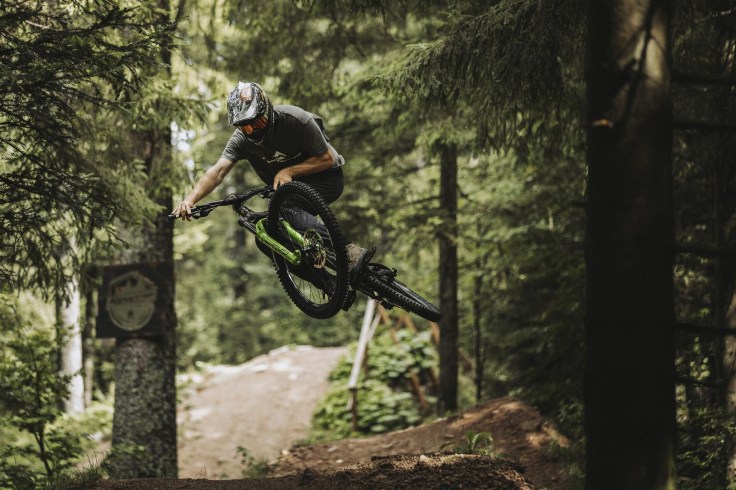 un'atleta in mountain bike su percorsi e sentieri dedicati alla discesa e alle discipline gravity in bike park