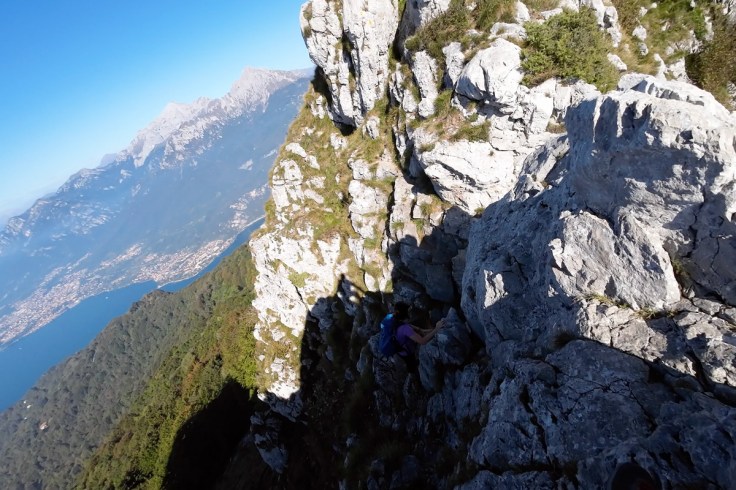 un'escursionista si cimenta su un passaggio roccioso caratterizzato da una forte esposizione