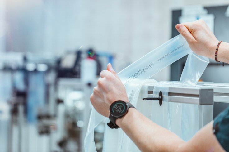 una camera d'aria in plurietano plastico (TPU) viene ispezionata da un addetto al controllo qualità