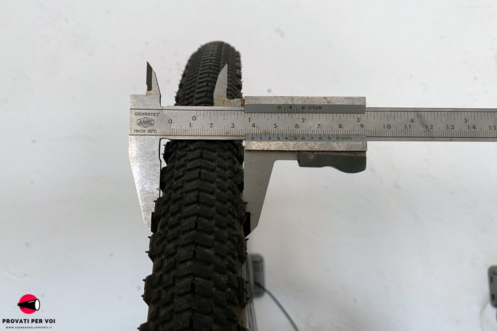 un operatore misura al calibro la sezione di uno pneumatico per bicicletta