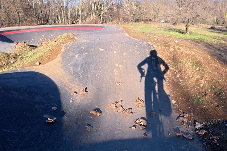 l'ombra di un ciclista in sella alla sua bicicletta mentre si allena sul nuovo circuito pumptrack di Cairate in provincia di Varese