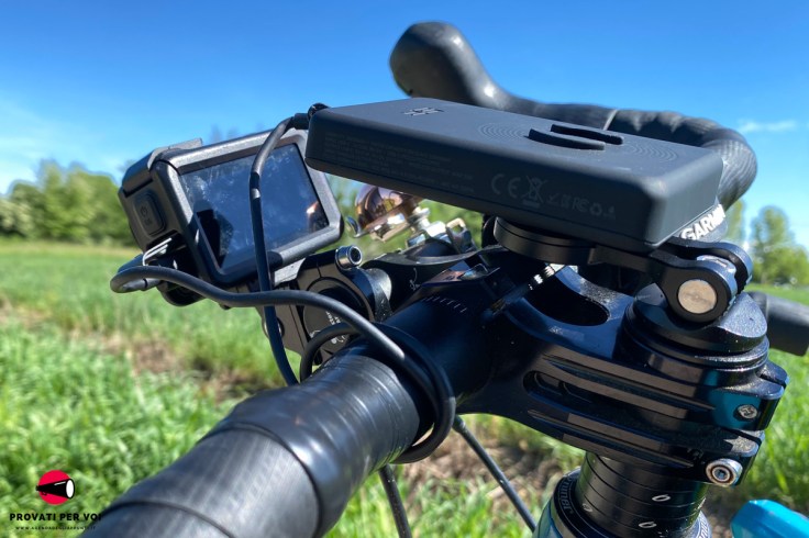 il power bank SP Connect, agganciato al supporto da manubrio, è collegato con la action camera DJI OM5 Pro per la ricarica attraverso cavo USB-C
