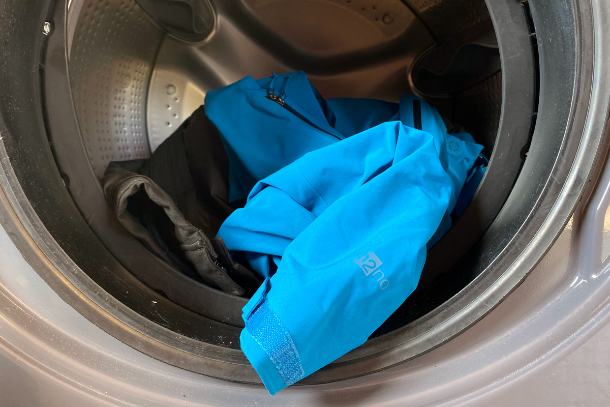 Capi di abbigliamento antipioggia nel cesto della lavatrice prima di avviare il lavaggio specifico per questo genere di prodotti