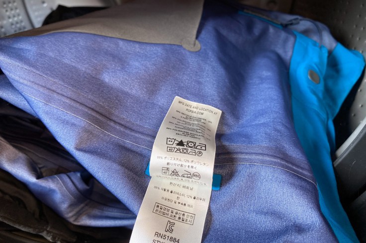 l'etichetta con le istruzioni di lavaggio di un capo di abbigliamento impermeabile e antipioggia