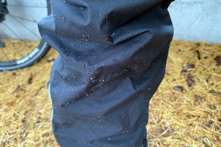 micro particelle di pioggia formano delle gocce sul tessuto di un pantalone impermeabile a riprova del trattamento antipioggia e della cura del capo stesso