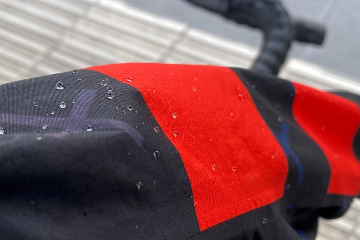 micro particelle di pioggia formano delle gocce sul tessuto di una giacca impermeabile a riprova del trattamento antipioggia e della cura del capo stesso