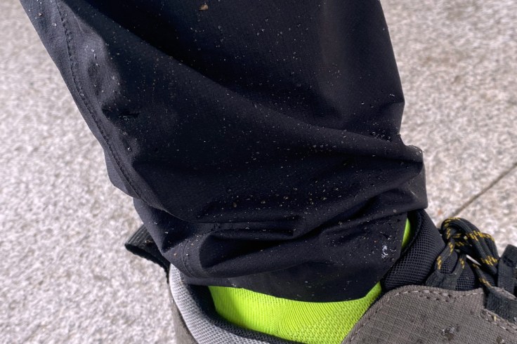 micro particelle di pioggia formano delle gocce sul tessuto di un pantalone impermeabile a riprova del trattamento antipioggia e della cura del capo stesso