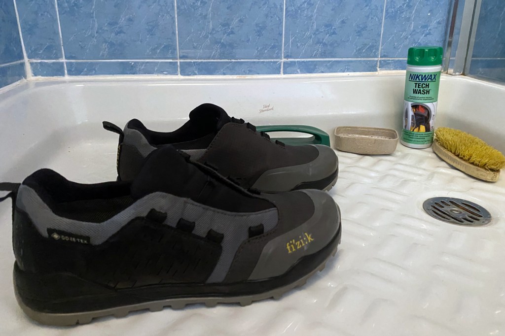 un paio di scarpe impermeabili vengono lavate con prodotti specifici per mantenere il trattamento e le caratteristiche per un piede sempre all'asciutto