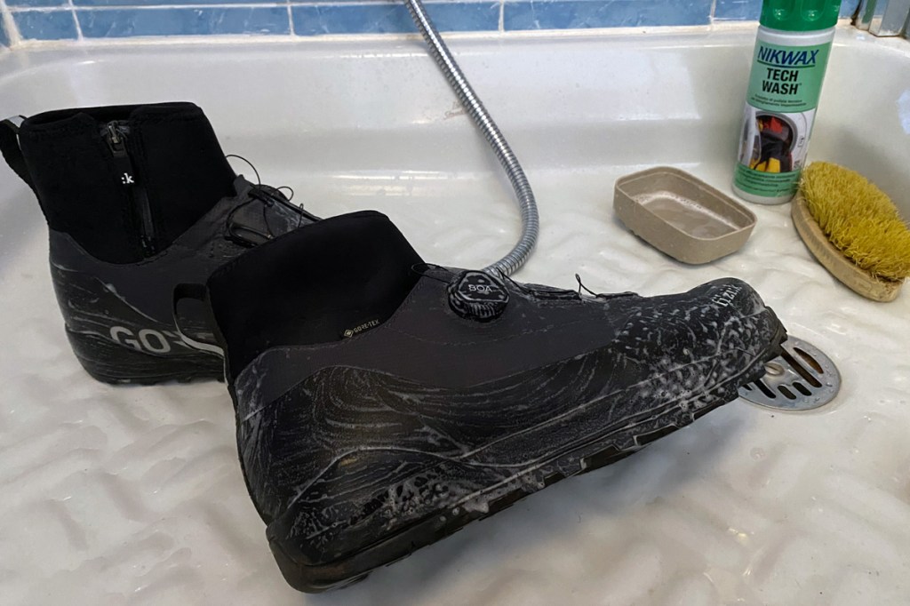 un paio di scarpe impermeabili vengono lavate con prodotti specifici per mantenere il trattamento e le caratteristiche per un piede sempre all'asciutto