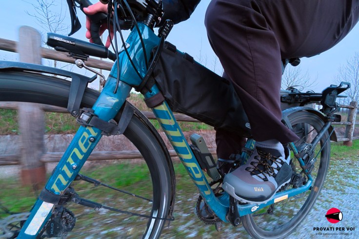 un ciclista in sella alla sua gravel bike percorre una strada bianca in ghiaia alle porte di Milano