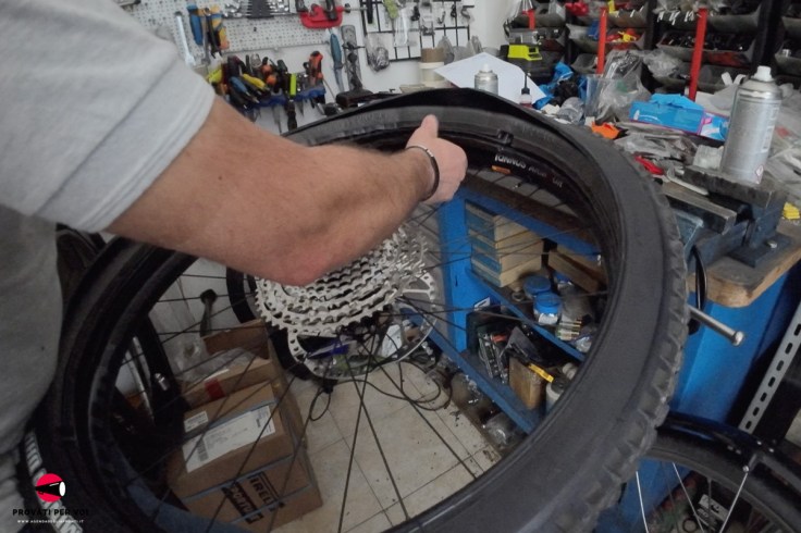 un meccanico per biciclette installa un inserto all'interno di uno pneumatico tubeless per migliorare comfort, prestazioni di guida, protezione del cerchio e capacità rum flat dello pneumatico