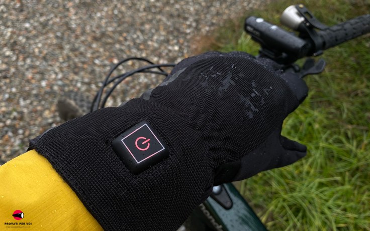 Primo piano sul pulsante di accensione di un guanto invernale termico, impermeabile e riscaldato