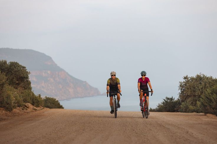 Due ciclisti pedalano su una strada panoramica costiera