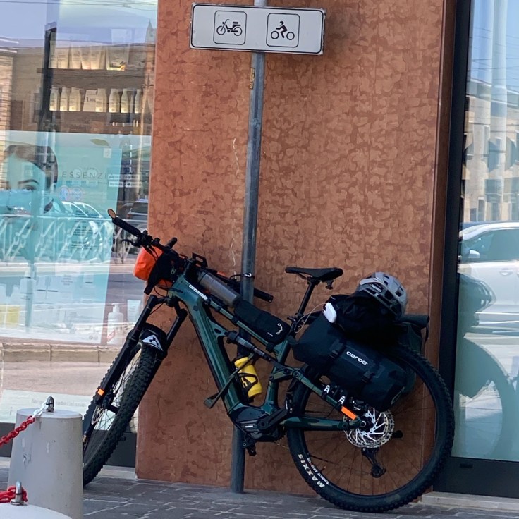 E-MTB parcheggiata accanto a un palo della segnaletica durante una sosta in cittร